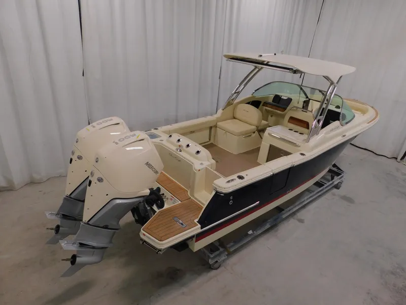 Slide: The Image of 2024 Chris-Craft Calypso 28 boat with dual outboard engines in a showroom. - 13