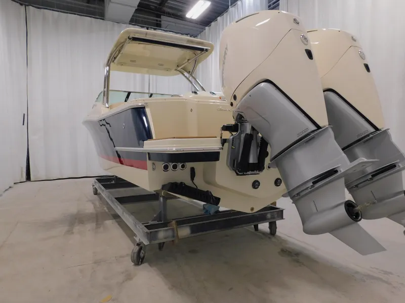 Slide: The Image of 2024 Chris-Craft Calypso 28 boat with dual outboard engines in a showroom. - 14