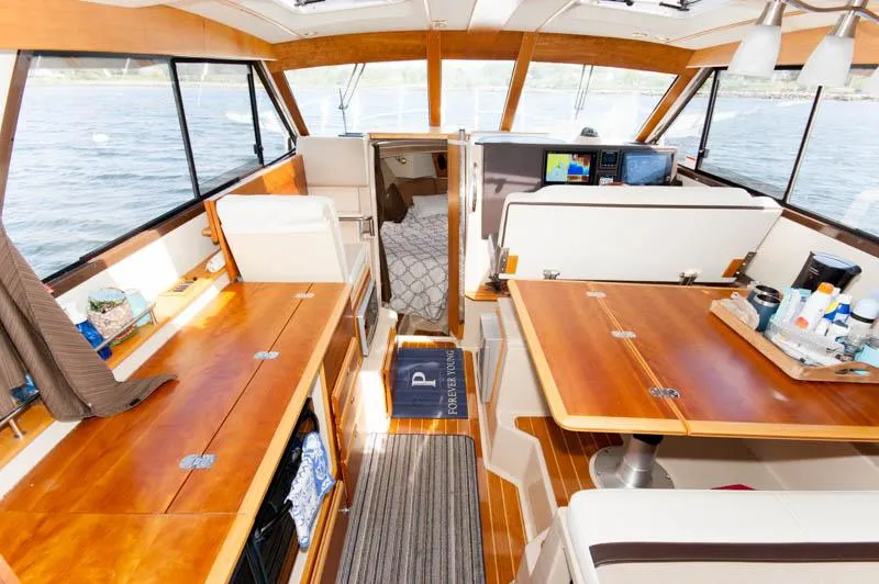 Slide: The Image of Interior of 2016 Cutwater 30 Sedan boat with wooden furnishings and panoramic windows. - 13