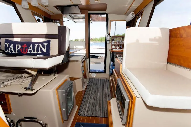 Slide: The Image of Interior of a 2016 Cutwater 30 Sedan boat with captain's chair and seating area. - 14