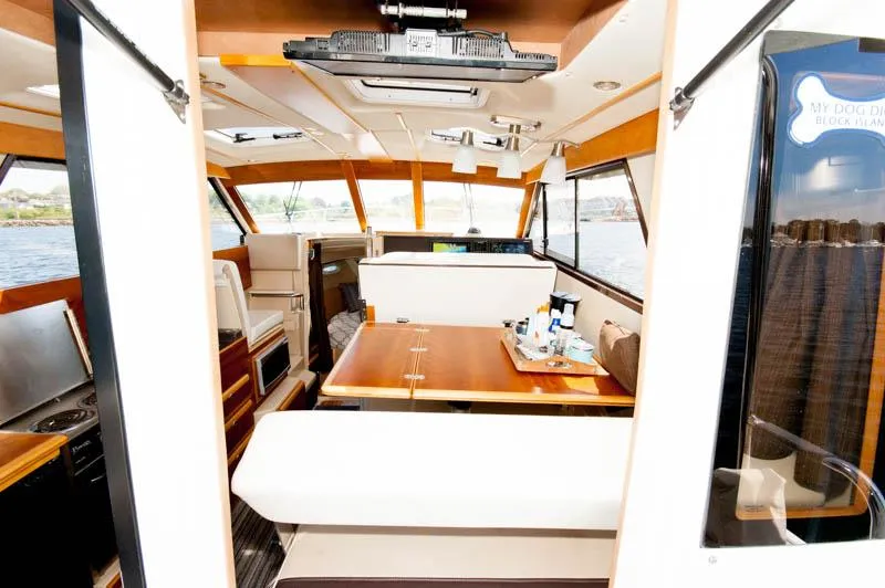 Slide: The Image of Interior of a 2016 Cutwater 30 Sedan boat with dining area and helm station. - 15
