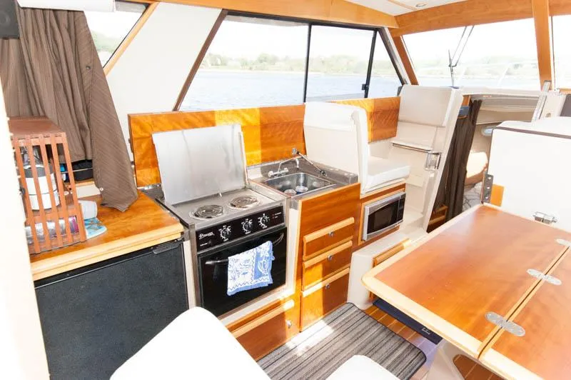 Slide: The Image of Interior of 2016 Cutwater 30 Sedan with kitchen and dining area. - 16