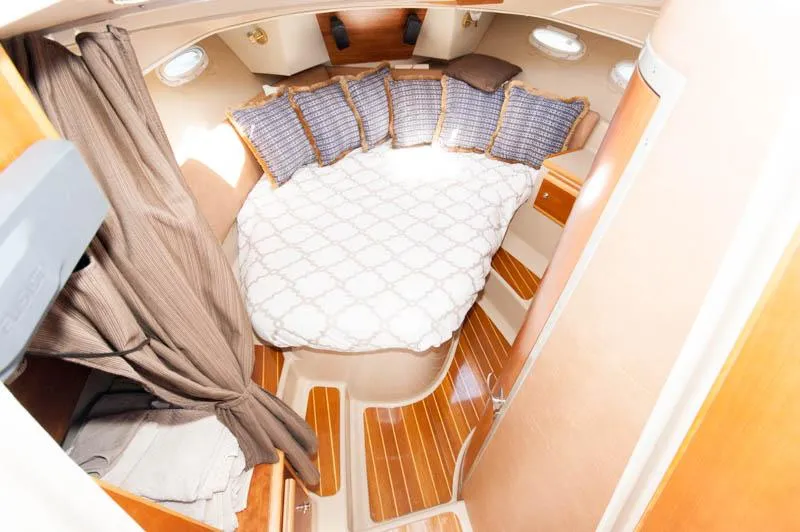 Slide: The Image of 2016 Cutwater 30 Sedan cabin with bed, pillows, and wooden flooring. - 17