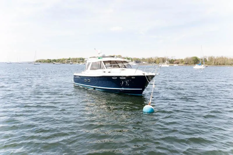 Slide: The Image of 2016 Cutwater 30 Sedan boat anchored on a calm lake. - 2