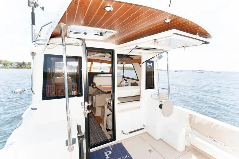 Slide: The Image of 2016 Cutwater 30 Sedan boat interior with open door, wooden ceiling, and ocean view. - 5