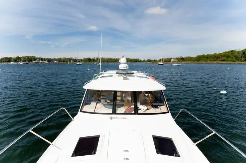 Slide: The Image of 2016 Cutwater 30 Sedan boat cruising on a calm lake under a clear sky. - 8