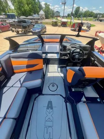 Slide: The Image of 2024 Axis Wake Research A225 boat interior with orange and gray seating. - 7