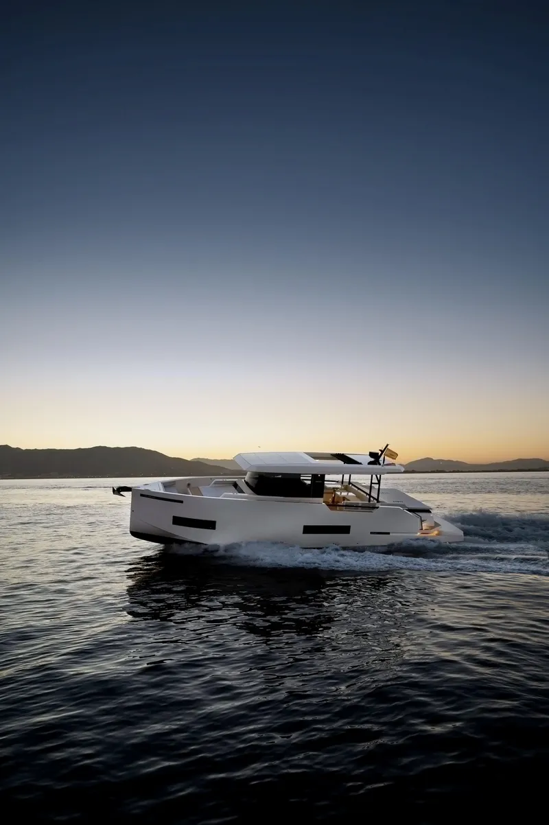 Slide: The Image of 2024 De Antonio Yachts D50 Coupé cruising at sunset on calm waters. - 2