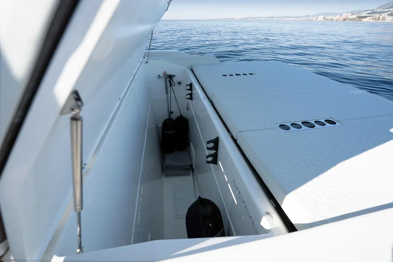 Slide: The Image of 2024 De Antonio Yachts D50 Coupé storage compartment with open hatch, overlooking calm sea. - 23