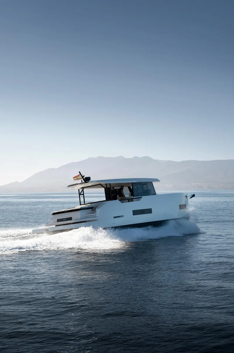 Slide: The Image of 2024 De Antonio Yachts D50 Coupé cruising on open water with scenic mountain backdrop. - 3