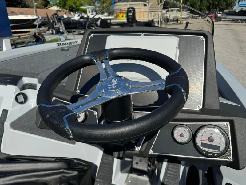 Slide: The Image of 2024 Ranger 518 Cup boat dashboard with steering wheel and gauges. - 2