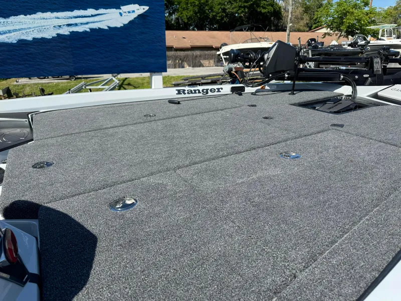Slide: The Image of 2024 Ranger 518 Cup boat deck with gray carpet and fishing equipment. - 6