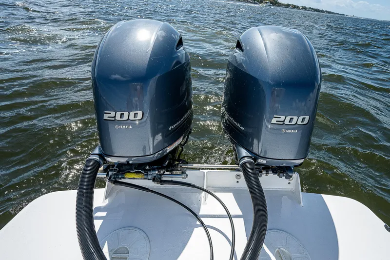 Slide: The Image of Twin Yamaha 200 engines on a 1969 Bertram 25 Moppie boat in open water. - 16