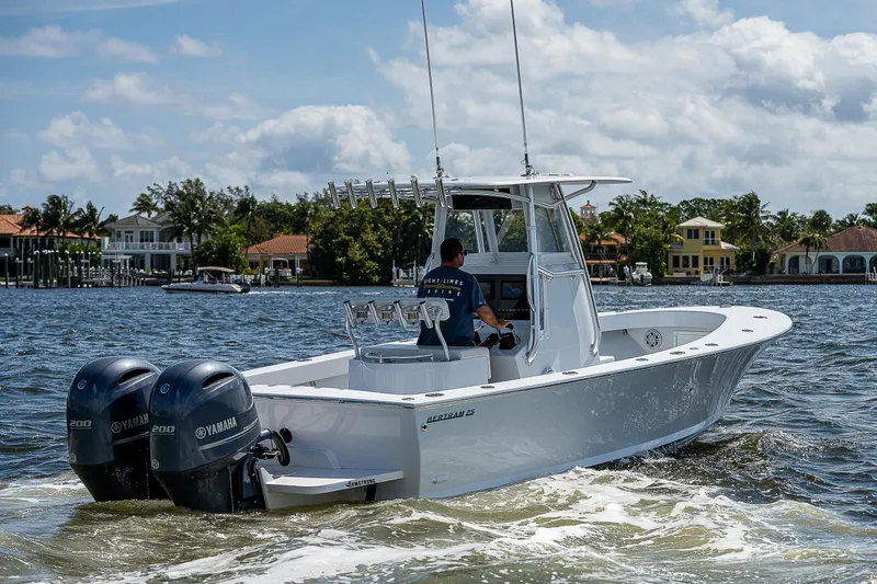 Slide: The Image of 1969 Bertram 25 Moppie boat cruising on a sunny day with twin Yamaha engines. - 25