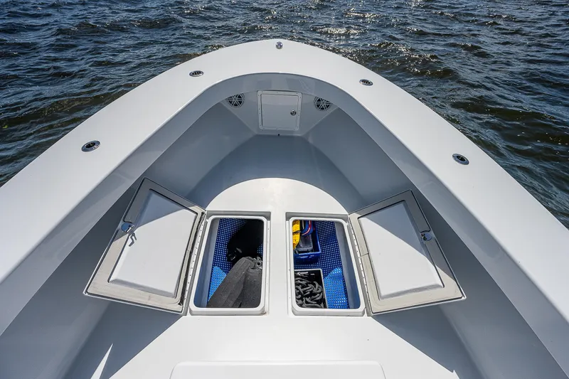 Slide: The Image of 1969 Bertram 25 Moppie boat bow with open storage compartments on the water. - 3