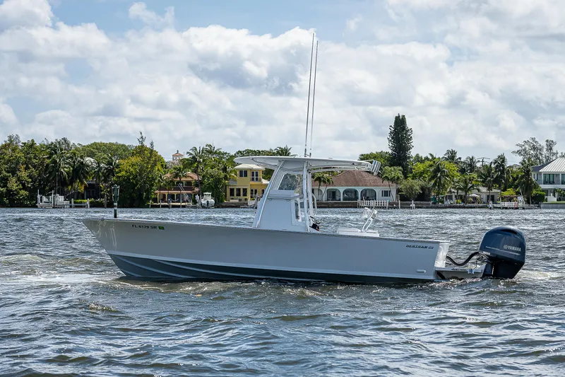 Slide: The Image of 1969 Bertram 25 Moppie boat cruising on a sunny day near waterfront homes. - 30