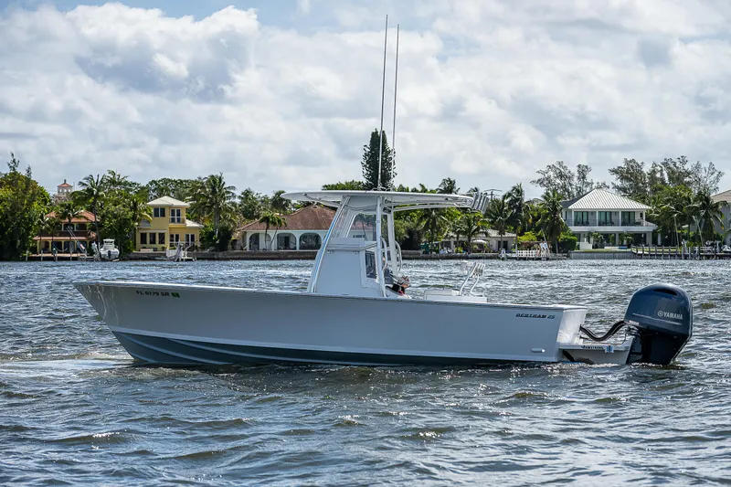 Slide: The Image of 1969 Bertram 25 Moppie boat cruising on a sunny day near waterfront homes. - 31