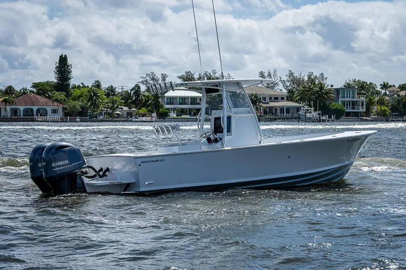 Slide: The Image of 1969 Bertram 25 Moppie boat cruising on a sunny day near waterfront homes. - 38