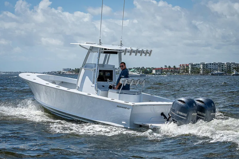 Slide: The Image of 1969 Bertram 25 Moppie boat cruising on the water with twin Yamaha engines. - 43