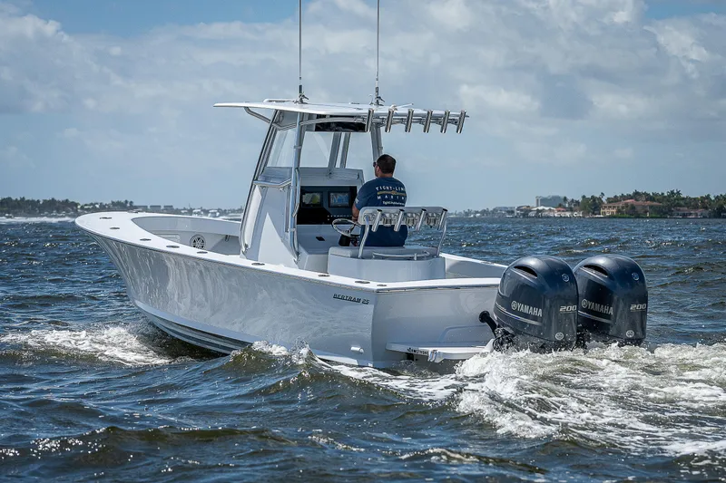 Slide: The Image of 1969 Bertram 25 Moppie boat cruising on the water with twin Yamaha outboard engines. - 44