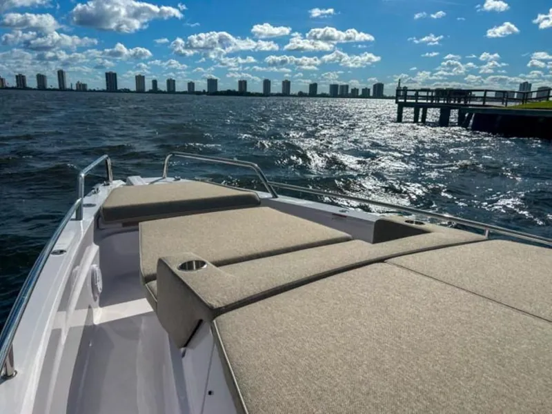 Slide: The Image of 2024 Axopar 37 Sun Top on water with city skyline in background. - 13