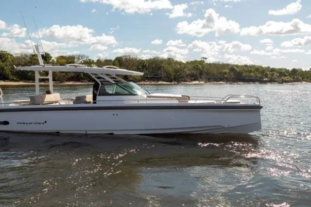 Slide: The Image of 2024 Axopar 37 Sun Top boat cruising on a sunny day. - 2