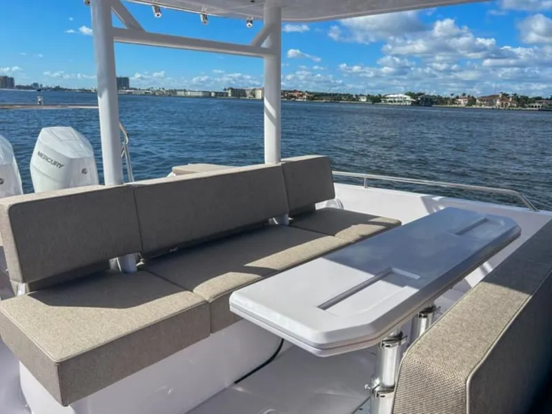 Slide: The Image of 2024 Axopar 37 Sun Top boat with seating area and table on a sunny day. - 24