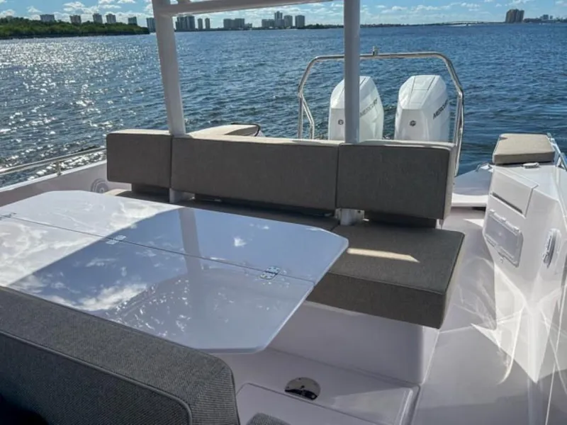 Slide: The Image of 2024 Axopar 37 Sun Top boat with seating area and twin engines on a sunny day. - 25