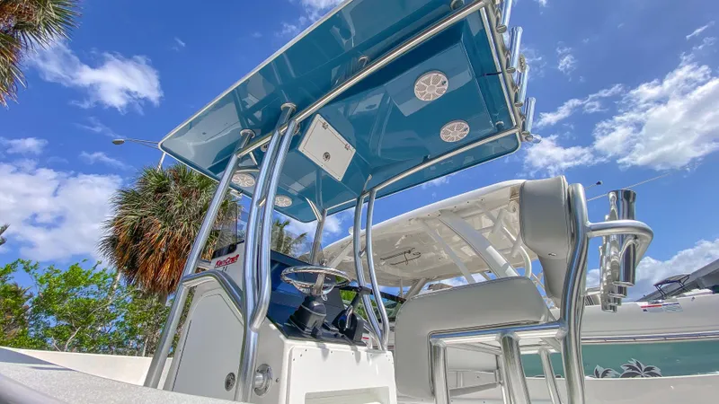 Slide: The Image of 2024 KenCraft 21 boat with T-top and seating, under a clear blue sky. - 5