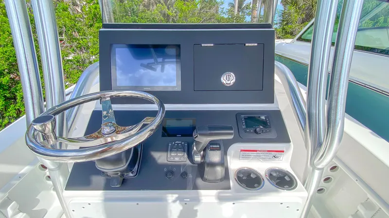 Slide: The Image of 2024 KenCraft 21 boat dashboard with steering wheel, navigation screen, and controls. - 7