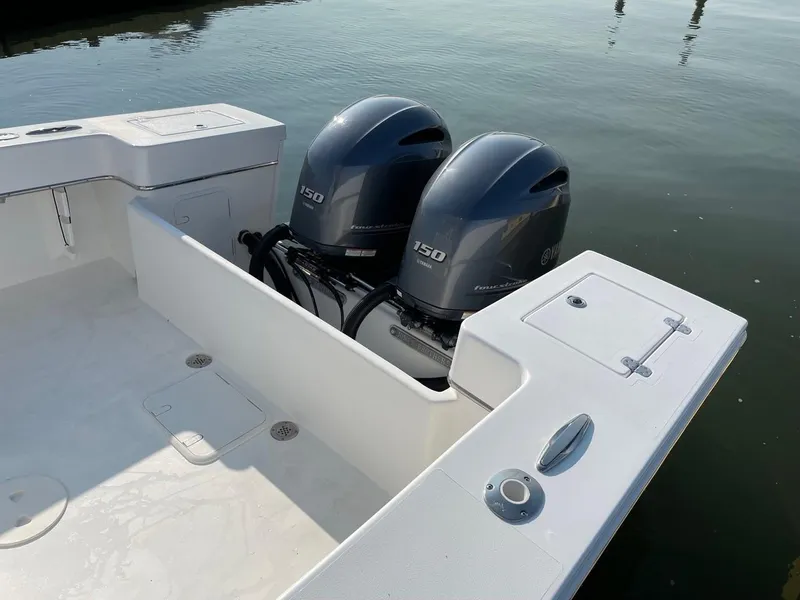 Slide: The Image of 2025 Jones Brothers 26 Cape Fisherman boat, front view, docked near a warehouse. - 11