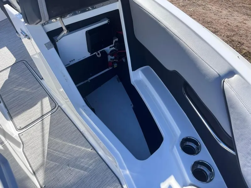 Slide: The Image of 2024 Cobalt CS23 boat interior storage compartment with cup holders and seating area. - 21