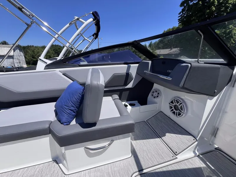 Slide: The Image of 2024 Cobalt CS23 boat interior with gray seating and blue pillow, featuring modern design elements. - 26