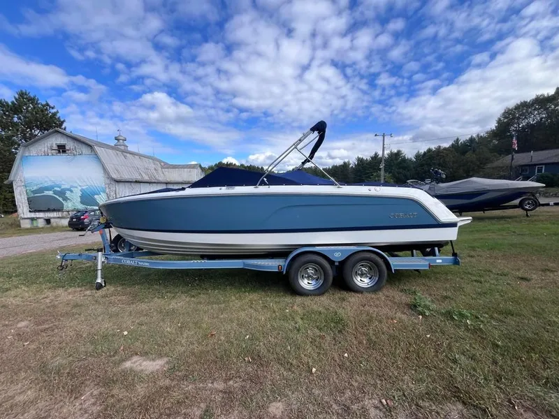 Slide: The Image of 2024 Cobalt CS23 boat on trailer, parked on grass under a partly cloudy sky. - 4
