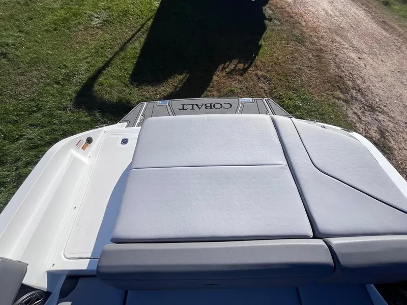 Slide: The Image of 2024 Cobalt CS23 boat with cushioned seating on a grassy area. - 47