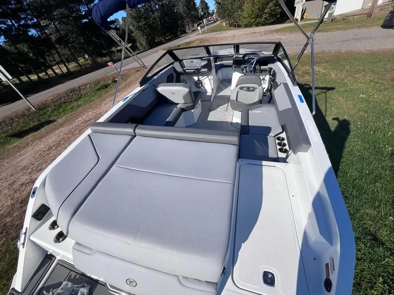 Slide: The Image of 2024 Cobalt CS23 boat with spacious seating and sleek design on grassy area. - 49