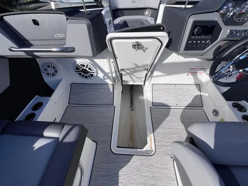 Slide: The Image of 2024 Cobalt CS23 boat interior with open storage compartment and modern dashboard. - 61