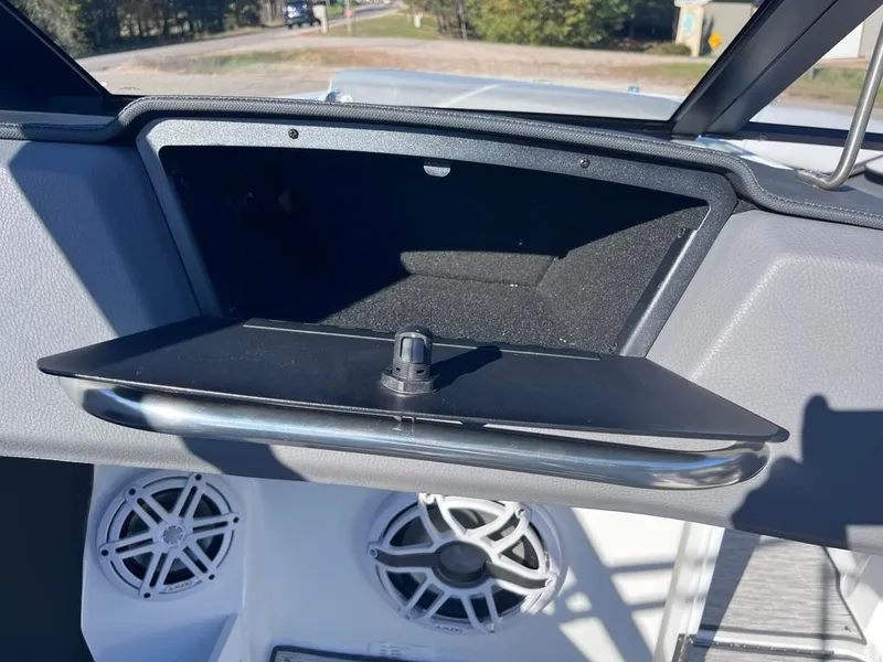 Slide: The Image of 2024 Cobalt CS23 boat dashboard with open glove compartment and speakers. - 63
