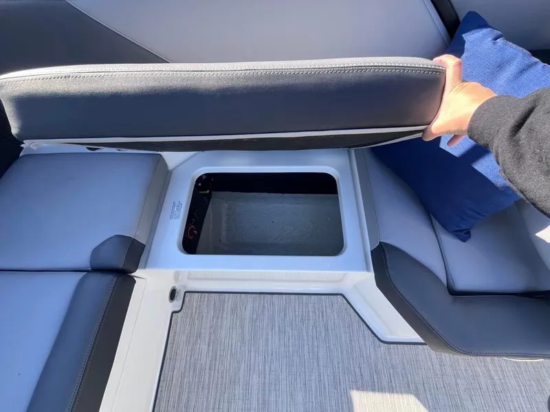Slide: The Image of 2024 Cobalt CS23 boat seat storage compartment with gray upholstery. - 68