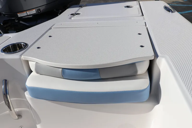 Slide: The Image of 2024 Robalo 206 Cayman boat seating and storage area, featuring white and blue cushions. - 12