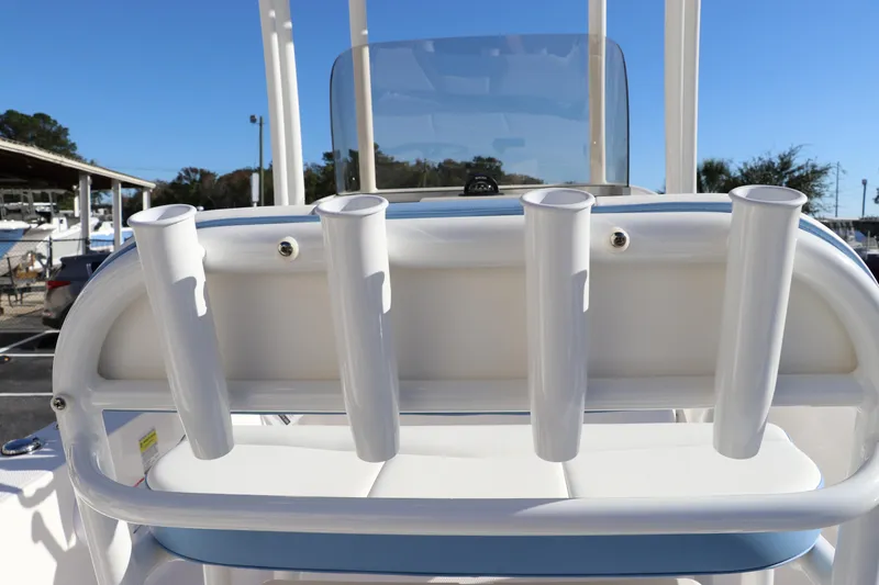 Slide: The Image of 2024 Robalo 206 Cayman boat with rod holders and windshield, docked outdoors. - 15