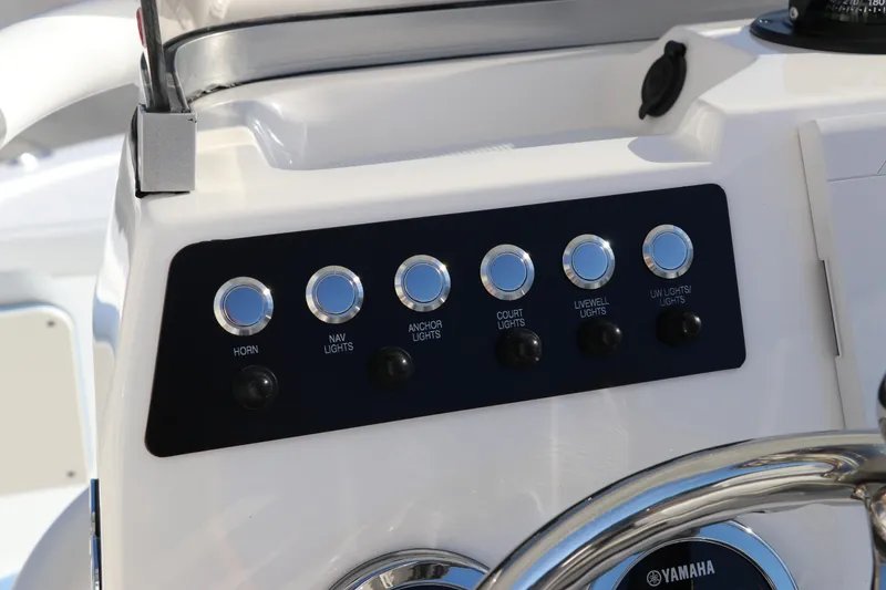 Slide: The Image of Control panel of 2024 Robalo 206 Cayman boat with labeled buttons and steering wheel. - 24