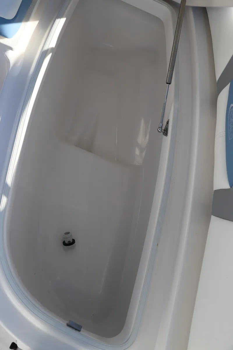 Slide: The Image of 2024 Robalo 206 Cayman boat storage compartment, white interior, open lid. - 35