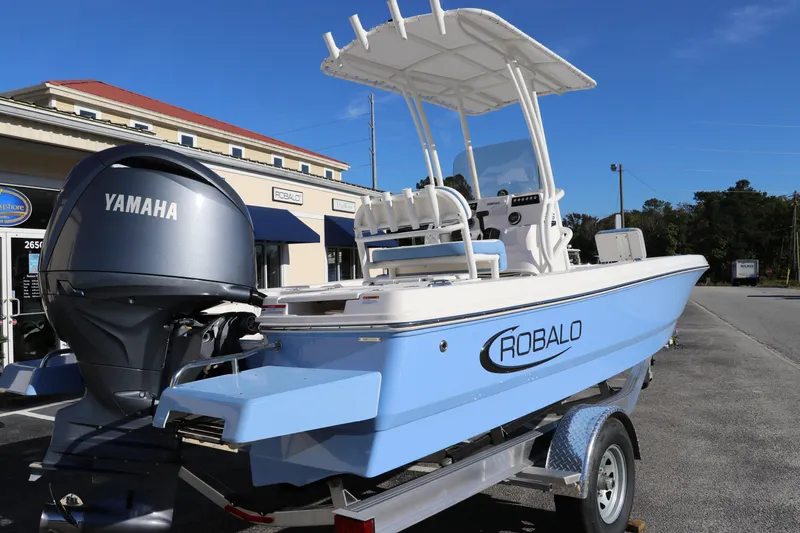 Slide: The Image of 2024 Robalo 206 Cayman boat with Yamaha engine on trailer, parked outside a building. - 6