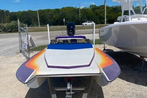 Slide: The Image of 2005 Liberator 21 speedboat with vibrant orange and purple accents, parked on a trailer. - 4