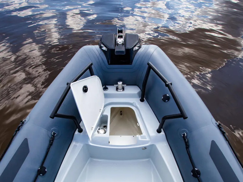 Slide: The Image of 2025 Zodiac Pro 5.5 boat interior with open storage compartment on calm water. - 10