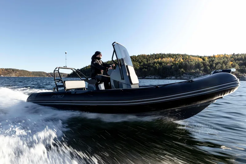 Slide: The Image of 2025 Zodiac Pro 5.5 boat speeding on water, with scenic forested shoreline in background. - 3