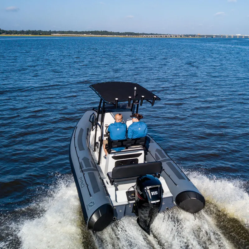 Slide: The Image of 2025 Zodiac Pro 5.5 boat cruising on open water with two passengers. - 5