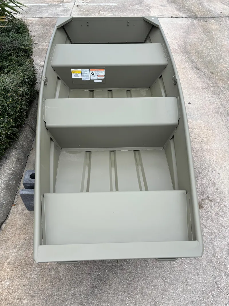 Slide: The Image of 2024 Tracker Grizzly 1036 Jon boat, top view, parked on concrete. - 2