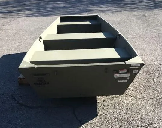 Slide: The Image of 2024 Tracker Grizzly 1036 Jon boat on pavement, showcasing its sturdy design. - 2